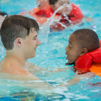 Child and swimming instructor learning how to swim at the Augusta Kroc Center