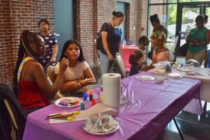 Students visit the face painting table at the HUB’s back to school event. Photo by Liz Wright.