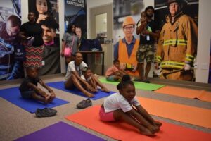 (Front row) Takenya Maddox’s daughter, Takenae, participates in yoga during the HUB’s back to school event on Saturday. Photo by Liz Wright.