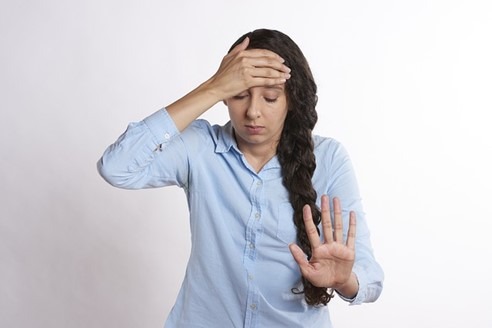 photo of female holding her head in anxiety